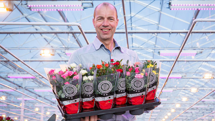 Leo van der Harg posa con flores de colores en las manos.