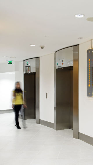 Pasillo y ascensores del edificio Tower 42, iluminado con iluminación para oficinas de Philips